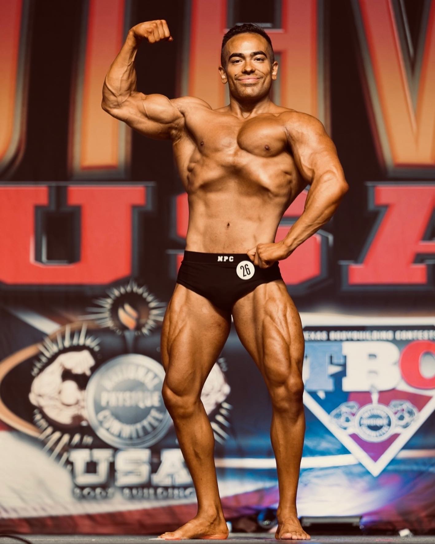 Coach Lalo bodybuilding competition pose showing championship physique